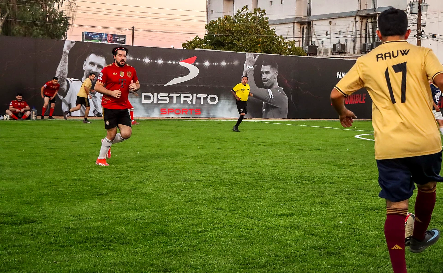 Partido en la cancha de Distrito Sports frente al mural principal